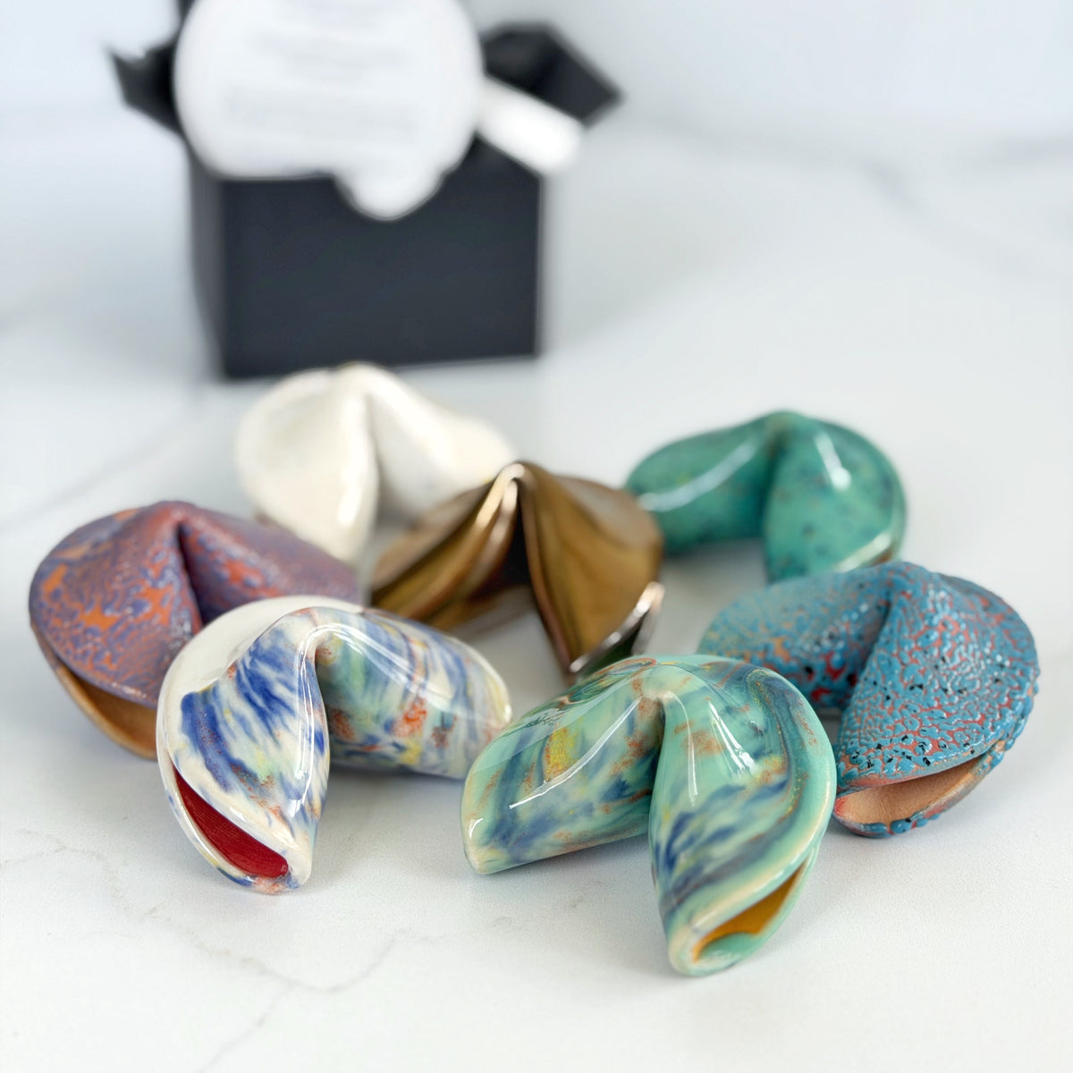 Assorted handmade ceramic fortune cookies in several colorways by Kathleen Kalish Ceramics