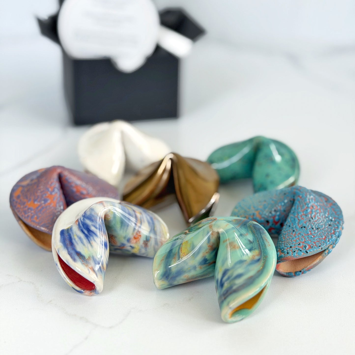 Assorted handmade ceramic fortune cookies in several colorways by Kathleen Kalish Ceramics