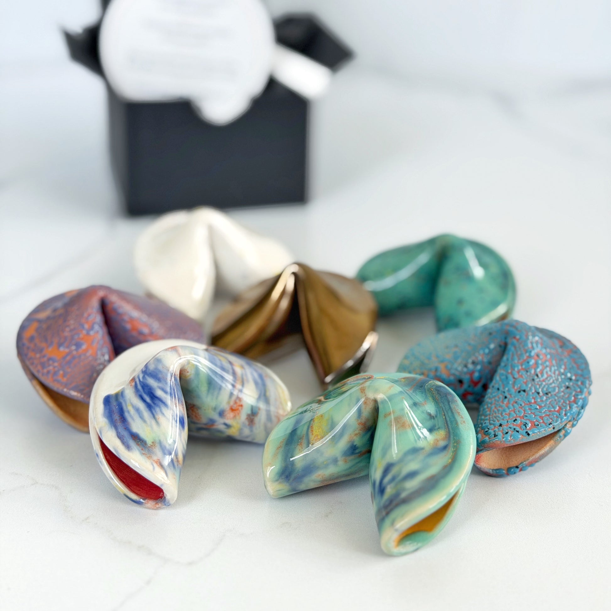 Assorted handmade ceramic fortune cookies in several colorways by Kathleen Kalish Ceramics
