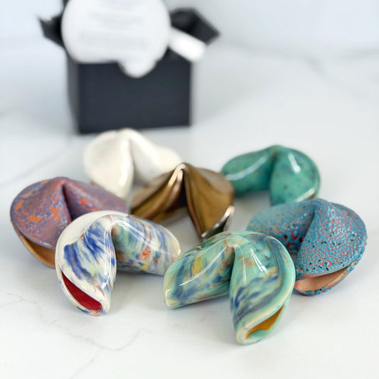 Assorted handmade ceramic fortune cookies in several colorways by Kathleen Kalish Ceramics