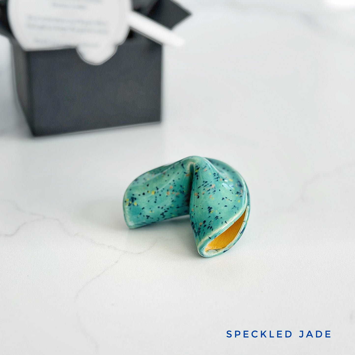 Jade and multi colored speckled ceramic fortune cookie, handmade and glazed by hand in Wilmington, NC by Kathleen Kalish Ceramics.