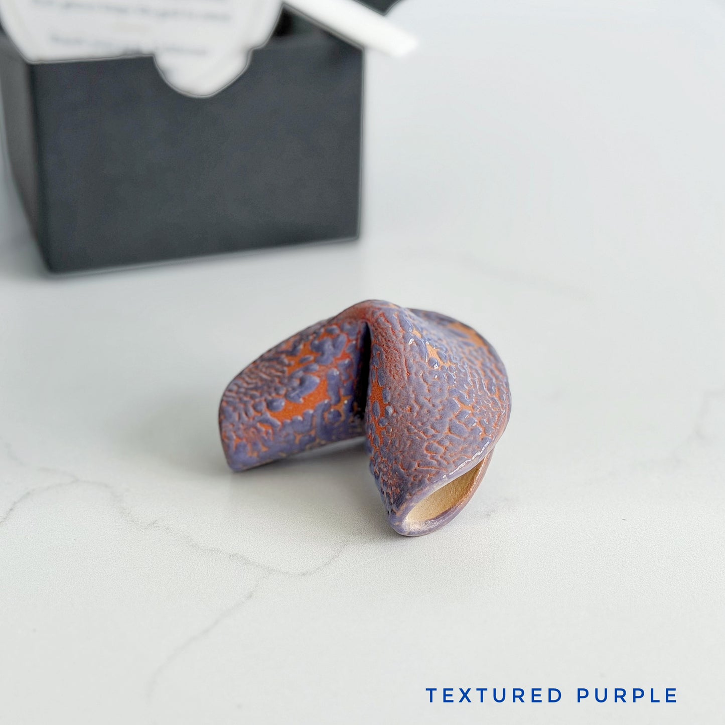 Textured purple ceramic fortune cookie, handmade and glazed by hand in Wilmington, NC by Kathleen Kalish Ceramics.