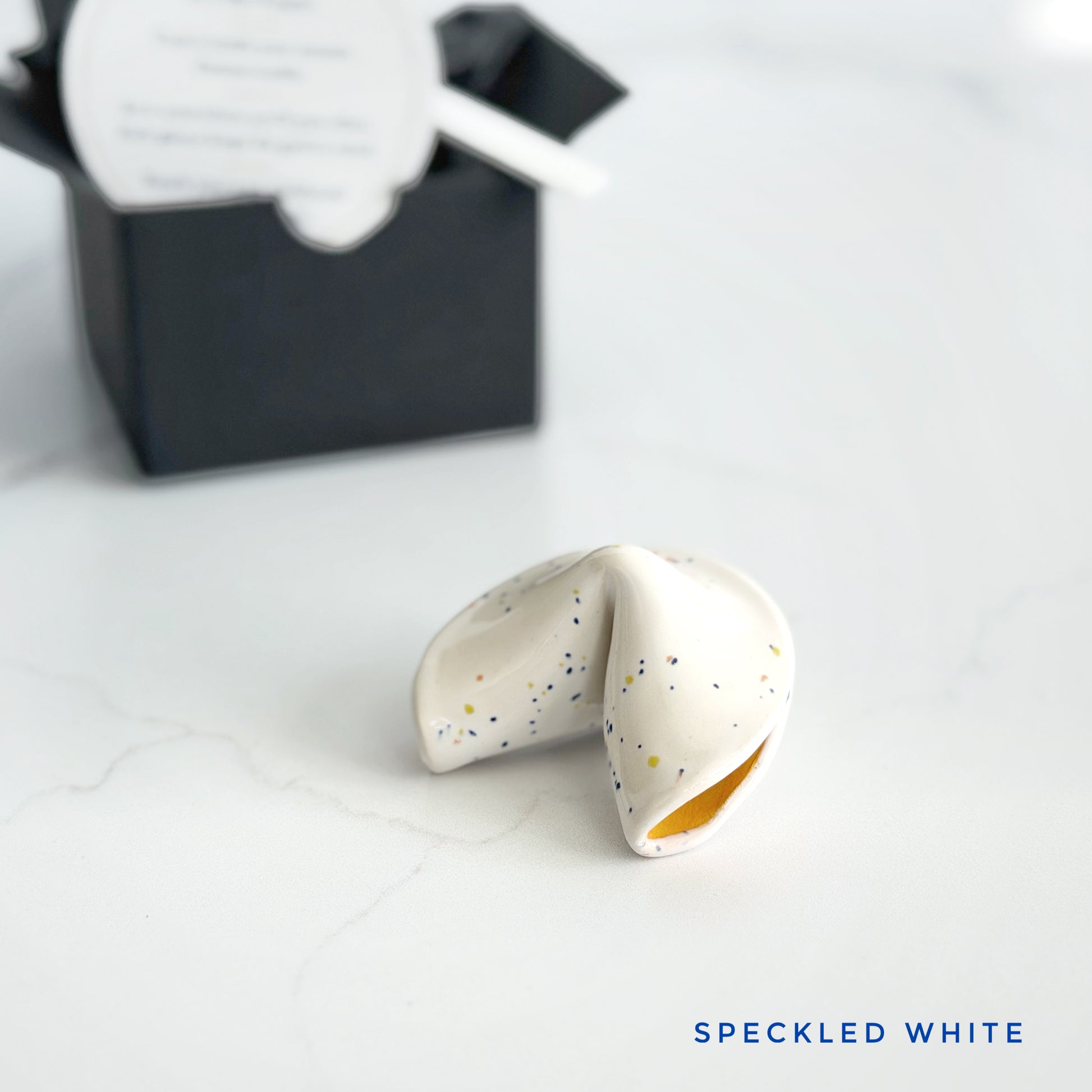 White speckled ceramic fortune cookie, handmade and glazed by hand in Wilmington, NC by Kathleen Kalish Ceramics.